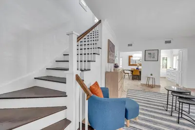 a living room with a staircase and a blue chair at Wonderful Tropical Pool House Miami South Brickell in Miami