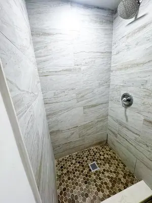 a bathroom with a shower with a tiled shower at Casita with pool, laundry and FREE parking in Miami