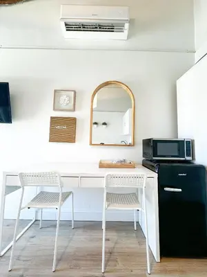 a kitchen with a white desk with a microwave and chairs at Casita with pool, laundry and FREE parking in Miami