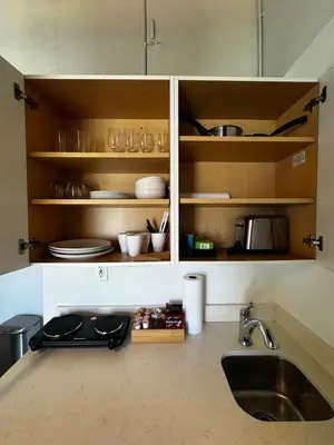 a kitchen counter with a sink and cabinets with dishes at Casita with pool, laundry and FREE parking in Miami