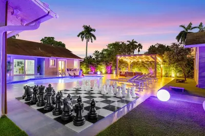 a pool with a chess board on a lawn at Luxury Villa Serena Heated Pool 15 min to Beach in Miami