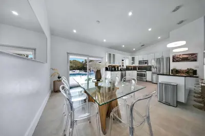 a dining room with a glass table and chairs at Luxury Villa Serena Heated Pool 15 min to Beach in Miami