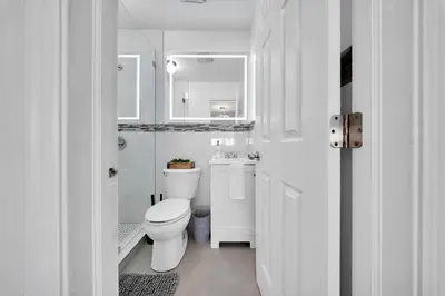 a white bathroom with a toilet and a sink at Luxury Villa Serena Heated Pool 15 min to Beach in Miami