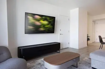 a living room with a tv hanging on a wall at Beachwalk -1 Bedroom W-Kitchen and Epic Views in Hallandale Beach