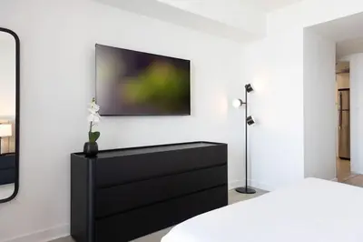 a black dresser with a flat screen tv on a wall at Beachwalk -1 Bedroom W-Kitchen and Epic Views in Hallandale Beach