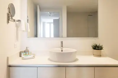 a white bathroom with a sink and a mirror at Beachwalk -1 Bedroom W-Kitchen and Epic Views in Hallandale Beach