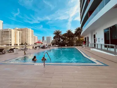 two people in a swimming pool in a building at 2 Bed & 2 Bath at Beachwalk - Amazing View on 29th in Hallandale Beach