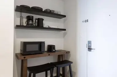 a kitchen with a table with two chairs and a microwave at Epic 29th-Floor Studio at Beachwalk Resort in Hallandale Beach