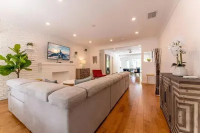 a living room with a large couch and a fireplace at Secluded Villa with 3 bedrooms and Heated Pool in Miami Beach