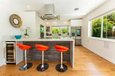 a kitchen with orange bar stools in front of a counter at Secluded Villa with 3 bedrooms and Heated Pool in Miami Beach