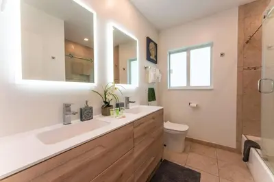 a bathroom with a sink and a toilet and a mirror at Secluded Villa with 3 bedrooms and Heated Pool in Miami Beach