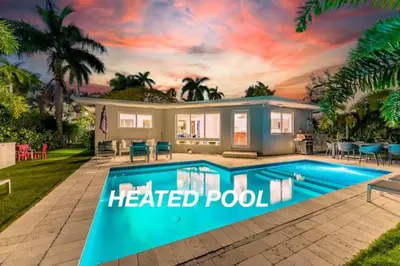 a house with a heated pool in front of it at Secluded Villa with 3 bedrooms and Heated Pool in Miami Beach