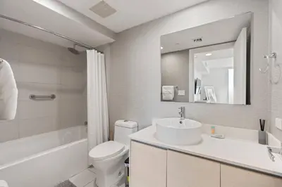 a bathroom with a sink and a toilet and a mirror at WATERFRONT Luxury 3 Bed 3 Bath Suite in Hallandale Beach
