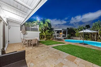 a patio with a table and chairs and a pool at Fort Lauderdale Water Front Oasis in Fort Lauderdale