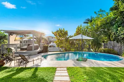 a backyard with a swimming pool and an umbrella at Fort Lauderdale Water Front Oasis in Fort Lauderdale