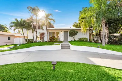 a house with palm trees and a driveway at Fort Lauderdale Water Front Oasis in Fort Lauderdale