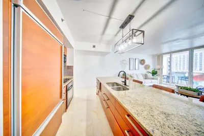a kitchen with a sink and a couch at South City Suites in Hallandale Beach