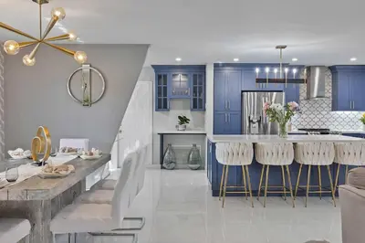 a kitchen with blue cabinets and a table with bar stools at Modern Hollywood 3BR House Pool Jacuzzi in Hollywood