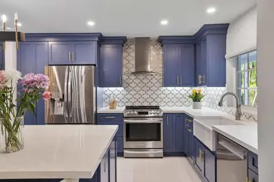 a kitchen with blue cabinets and a stainless steel refrigerator at Modern Hollywood 3BR House Pool Jacuzzi in Hollywood