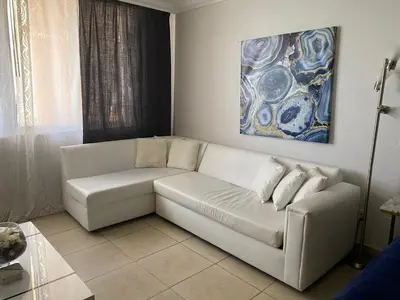 a white couch in a living room with a painting at Lujoso Departamento Con VIstas Al Mar- Miami Beach in Sunny Isles Beach