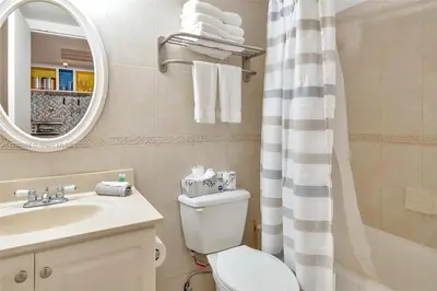 a bathroom with a toilet and a sink and a mirror at Lujoso Departamento Con VIstas Al Mar- Miami Beach in Sunny Isles Beach