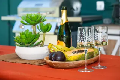 a table with a bowl of fruit and two wine glasses at 3-Bedroom Tropical Villa with Heated Pool in Fort Lauderdale in Fort Lauderdale