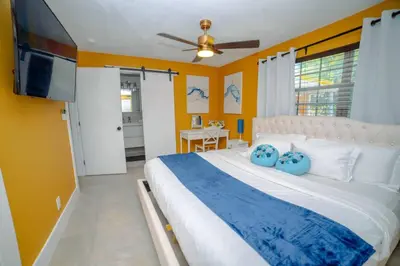 a bedroom with a large bed and a flat screen tv at 3-Bedroom Tropical Villa with Heated Pool in Fort Lauderdale in Fort Lauderdale