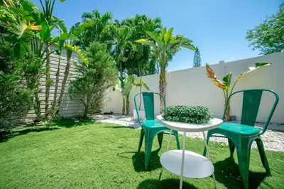 a patio with two chairs and a table with a plant at 3-Bedroom Tropical Villa with Heated Pool in Fort Lauderdale in Fort Lauderdale