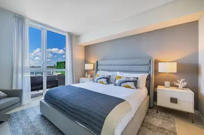 a bedroom with a large bed and a large window at Champagne at Tiffany's - Luxury Condo by the Beach in Fort Lauderdale