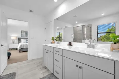 a white bathroom with two sinks and a large mirror at Royal Palm Gateway - Spacious Family Retreat in Sunny Homestead in Homestead