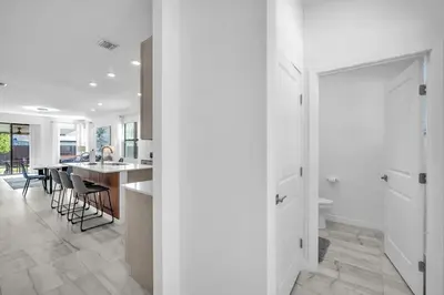a kitchen and living room with white walls and a table at Royal Palm Gateway - Spacious Family Retreat in Sunny Homestead in Homestead