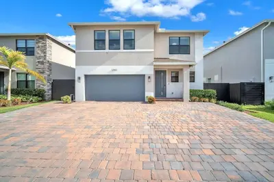 a house with a brick driveway in front of it at Royal Palm Gateway - Spacious Family Retreat in Sunny Homestead in Homestead