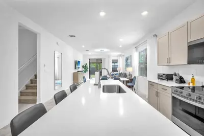 a white kitchen with a large white counter top at Royal Palm Gateway - Spacious Family Retreat in Sunny Homestead in Homestead