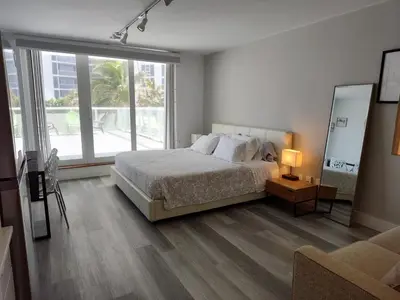 a bedroom with a bed and a large window at Estudios en las playa de Sunny Isles Beach in Sunny Isles Beach