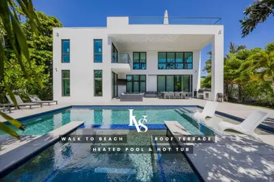 a house with a swimming pool in front of it at LVS Villa Blanco 5BR Coastal Oasis with Rooftop Sunset Deck Heated Pool Spa & Walk-to-Beach Access in Fort Lauderdale