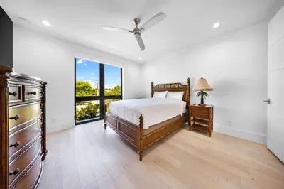 a bedroom with a bed and a large window at LVS Villa Blanco 5BR Coastal Oasis with Rooftop Sunset Deck Heated Pool Spa & Walk-to-Beach Access in Fort Lauderdale