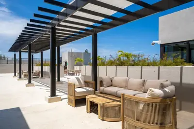 a patio with a couch and chairs under a pergola at New Spacious 3BR Apt With Rooftop Pool 2 Parking in Hollywood