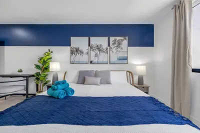 a bedroom with a large bed with a blue blanket at New Spacious 3BR Apt With Rooftop Pool 2 Parking in Hollywood