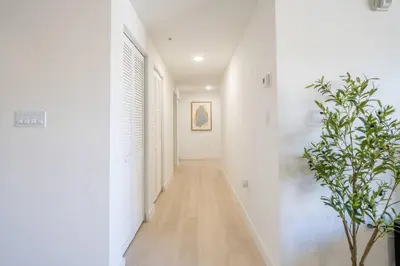 a hallway with white walls and a plant at New Spacious 3BR Apt With Rooftop Pool 2 Parking in Hollywood