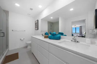 a white bathroom with a teddy bear sitting on a counter at New Spacious 3BR Apt With Rooftop Pool 2 Parking in Hollywood
