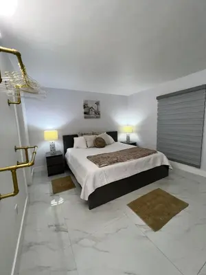 a bedroom with a large bed with two lamps on it at Miami City Escape in Hialeah
