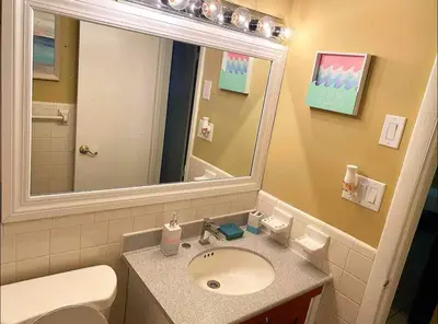 a bathroom with a sink and a mirror and a toilet at Lovely 2 Bedroom Condo With Free Parking & Wifi!! in Sunrise