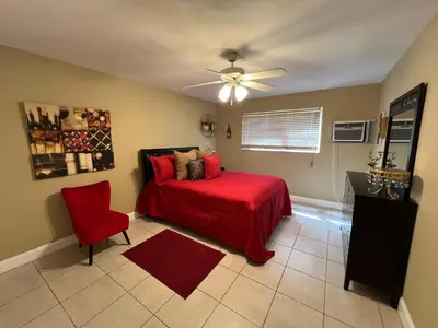 a bedroom with a red bed and a ceiling fan at Lovely 2 Bedroom Condo With Free Parking & Wifi!! in Sunrise