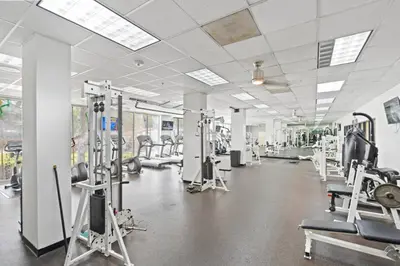 a gym with rows of treadmills and machines at SUNNY ISLES 4BR Pool & Beach Access in Sunny Isles Beach