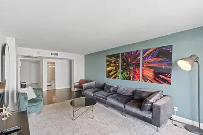 a living room with a couch and a painting on the wall at SUNNY ISLES 4BR Pool & Beach Access in Sunny Isles Beach