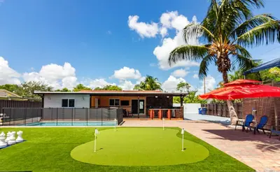 a golf course in the yard of a house at Waterfront 3BR with Pool Tiki Hut & Mini Golf in Miami Gardens