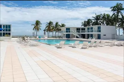 a swimming pool with lounge chairs and a building at UNIT #1108 Castle Beach Club Condominium in Miami Beach