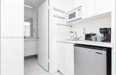 a white kitchen with white cabinets and a dishwasher at UNIT #1108 Castle Beach Club Condominium in Miami Beach