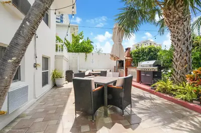 an outdoor patio with a table and chairs and a grill at Soleado Hotel in Fort Lauderdale