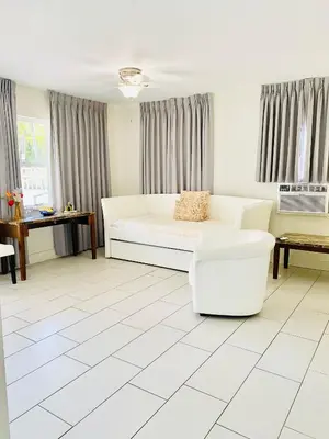 a white living room with a couch and a table at Soleado Hotel in Fort Lauderdale